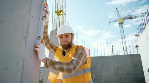 Construction Worker Using Level on Concrete Wall
