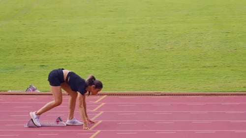 Asian young sportswoman sprint on a running track outdoors on stadium.