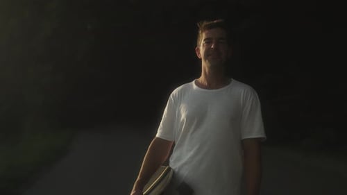 Young Man with Skateboard on a Sunny Day