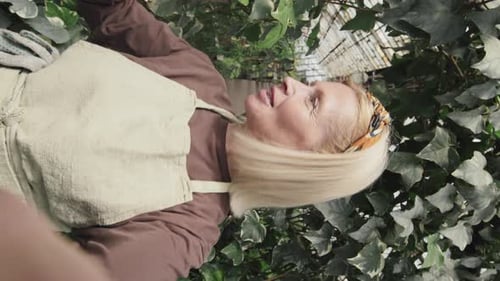 Woman Gardener Talking About Her Greenhouse Plants