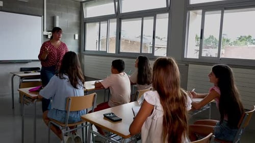 Diverse Group of Children Listening Female Teacher at Elementary School