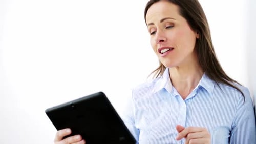 Smiling Woman Talking Holding a Tablet Device