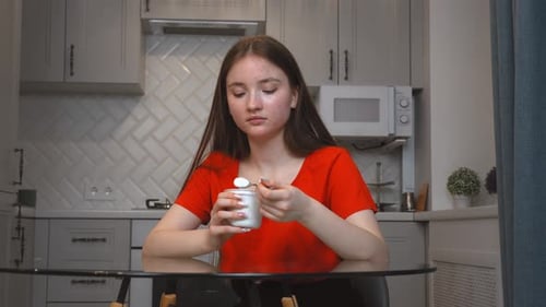 Girl Enjoying Yogurt at Kitchen Table Indoors