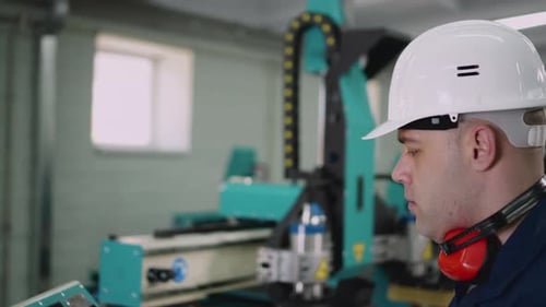 O operador da máquina CNC está olhando de perto a câmera