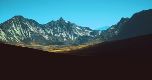 Majestic Mountain Range Under Clear Blue Sky with Distant Peaks
