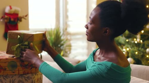 Woman Smiles with Christmas Gifts Indoors