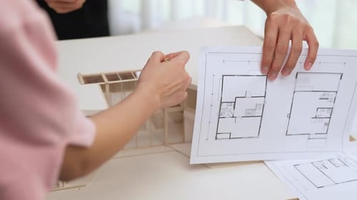 Architects Reviewing Blueprints and Model in Office