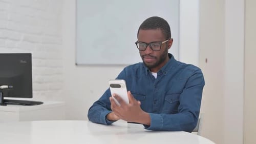 Man at Table Using Smartphone