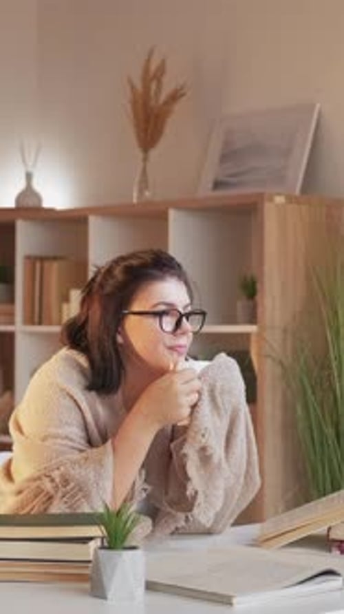 Woman Reading with Mug at Desk Indoors