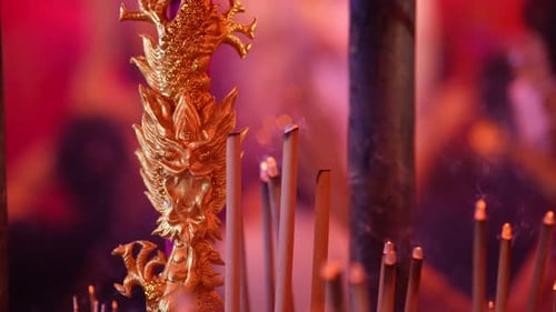 Golden dragon statue and burning incense sticks