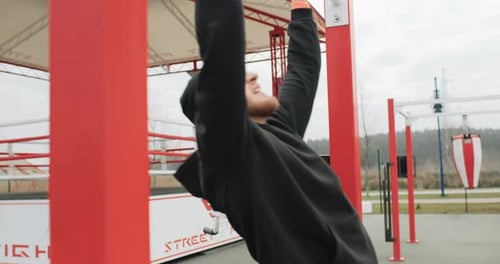 Training Motivation Athlete Man Working Out Outside on the Outdoor Gym Making Pull Ups Strong Fit