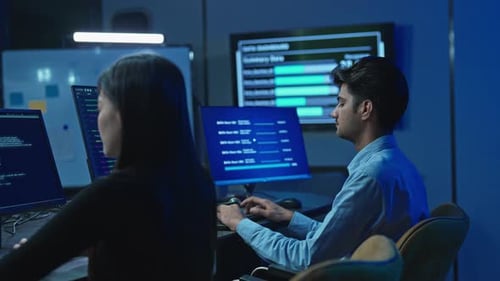 Software engineers collaborating on code and data in high-tech office