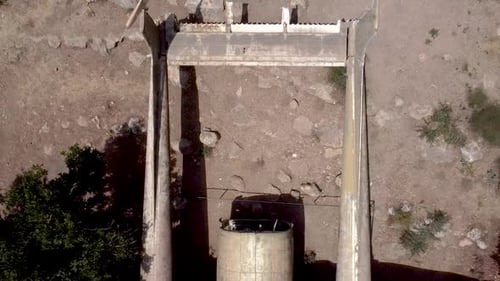 Aerial slow zoom out drone shot of an old dismantled army plane monument placed on an empty dirt fie