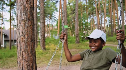 African American Young Boy Playing on Swing
