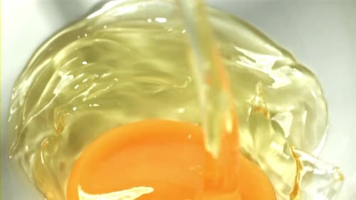 Ein rohes Ei fällt in eine Kappe, gefilmt mit einer Hochgeschwindigkeitskamera mit 1000 Bildern pro Sekunde
