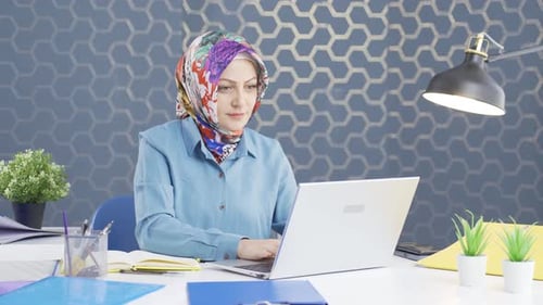 Mujer de negocios con hiyab mirando a la cámara con expresión de asombro.
