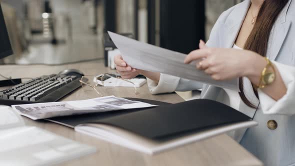 Female designer reviewing paperwork at office desk, Business, Corporate ...