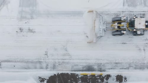 Static shot of snow plow moving through snow covered roads for clearing during blizzard.
