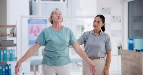 Senior Woman Doing Arm Raises With Therapist