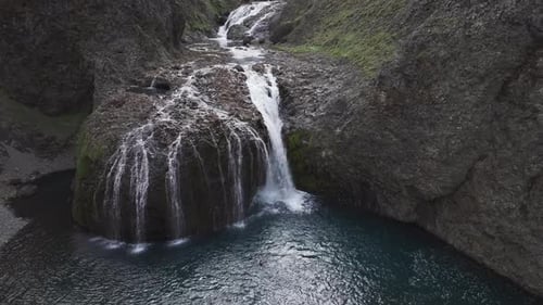 Aerial view of people jumping at Stjornarfoss waterfall, Iceland