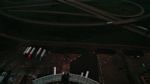 Semi trucks parking lot and interstate highway driving route at night, Wisconsin, Aerial revealing s