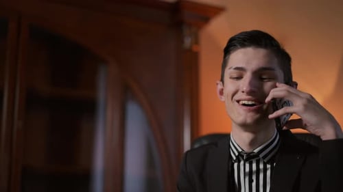 A Young Businessman Engaged in a Phone Call Within a Professional Office Environment