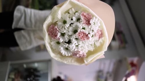 Florist Crafting Bouquet. Florist at Work. Florist makes bouquet in flower shop Lera Vertical