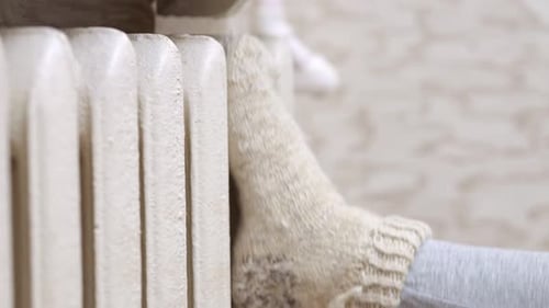 Feet in Woolen Socks on a Radiator