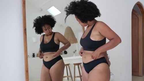 Mulher preocupada olha para seu próprio corpo insatisfeita com gordura, celulite, estrias, problema de