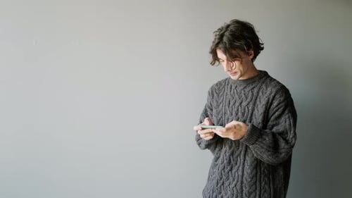 Young Man Scrolling on Smartphone
