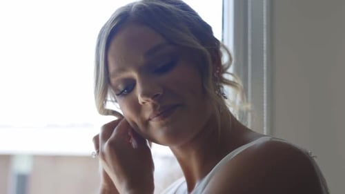 Blonde Woman Puts on Earring Before Wedding