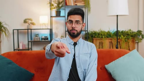 Glücklicher zufriedener Inder, der lächelt und in die Kamera zeigt, wählt den glücklichen Gewinner aus und wählt „Genehmigen“