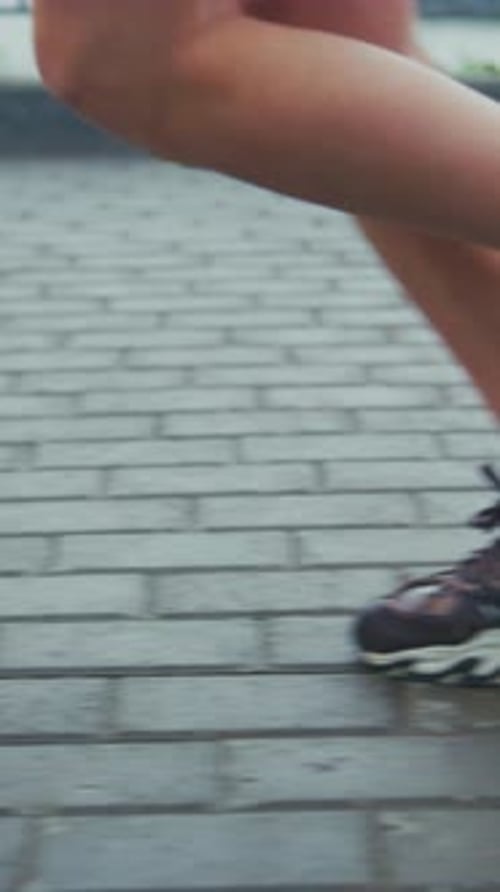 Legs and Feet Running on Brick Walkway