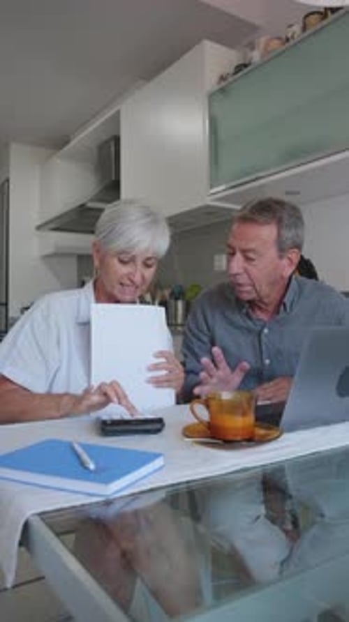 Couple Calculates Finances Together at Home at Table