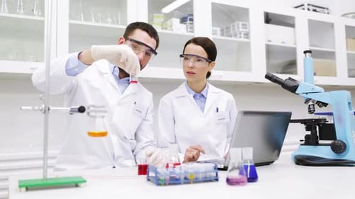 Jovens cientistas sacudindo reagente de vidro durante pesquisas clínicas em laboratório