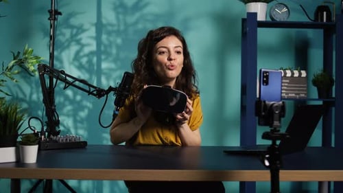 Woman Demonstrating a Virtual Reality Headset at Desk