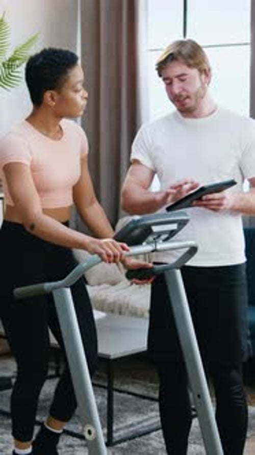 Woman and Man Setting Up Treadmill for Workout