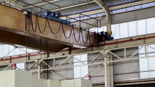 Close up shot moving overhead crane on roof of factory building