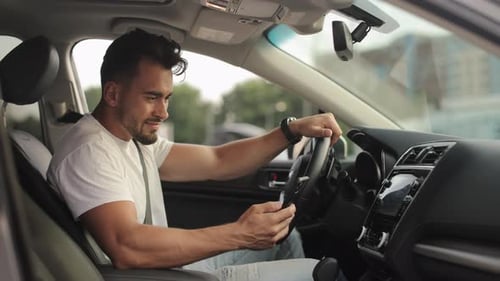 Man Sitting in Car Holding Smartphone