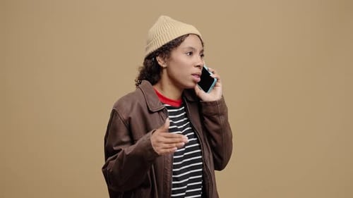 Annoyed Woman Arguing on Phone in Studio Setting