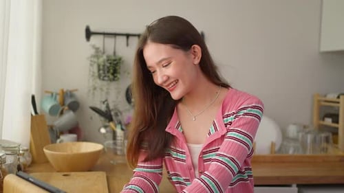 Smiling Woman Using Tablet in Sunny Kitchen