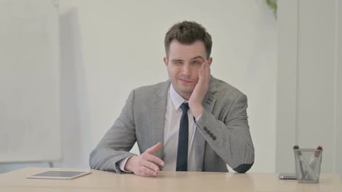 Man in Suit with Headache Rubbing Head