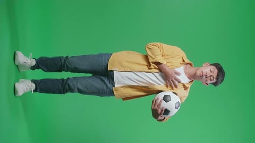 Young Adult Smiling with Soccer Ball on Green Screen