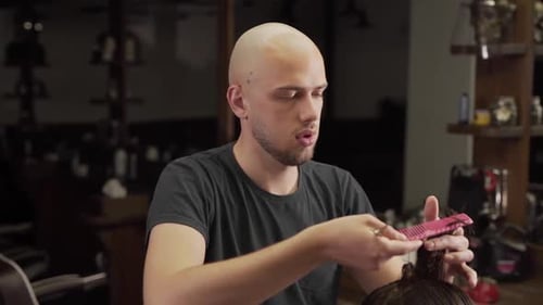 close-up of a barber performing a haircut of long male hair with scissors