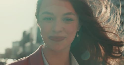 Smiling Woman's Radiant Face in City Sunlight
