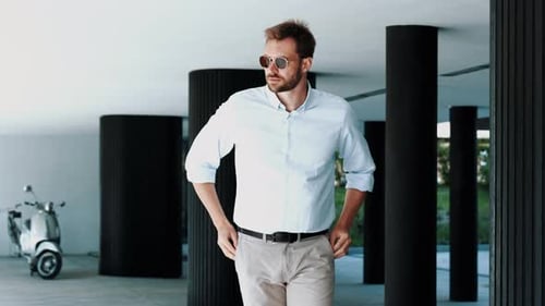 Stylish Man Puts on Sunglasses Outside Building