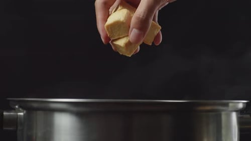 Close Up Of Chef's Hand Adding Tofu In The Soup Pot. Sukiyaki Or Shabu In A Pot