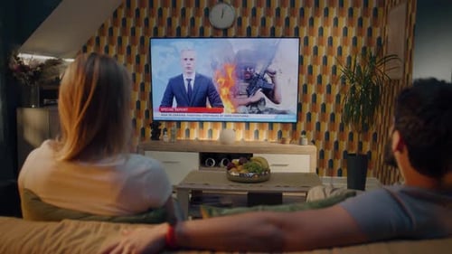 Couple Watching TV News About War in Ukraine