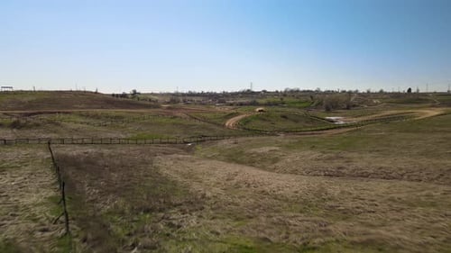 Realtime drone footage moving forward over a motocross track in a wild country park in Prairie City,