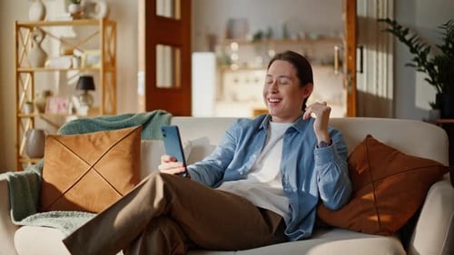 Man Relaxing on Couch Talking on Phone